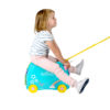 Trunki Una the Unicorn Rejsekuffert, pige sidder på kufferten og bliver trukket.